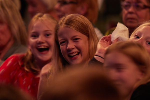 Young audience members laughing