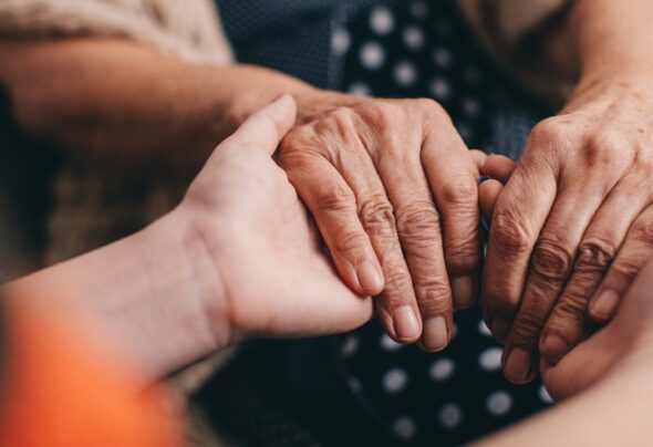 Two people of different ages holding hands - close-up of hands