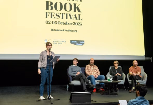 Flash fiction winners announcement by speaker on stage